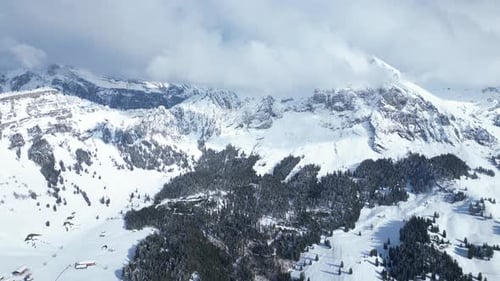 Aerial shot of beautiful Fronalpstock mountains under clouds during daytime in Glarus, Switzerland.