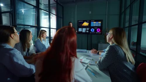 Smart Woman Business Coach Showing Diagrams On Multimedia Display For Women Colleagues