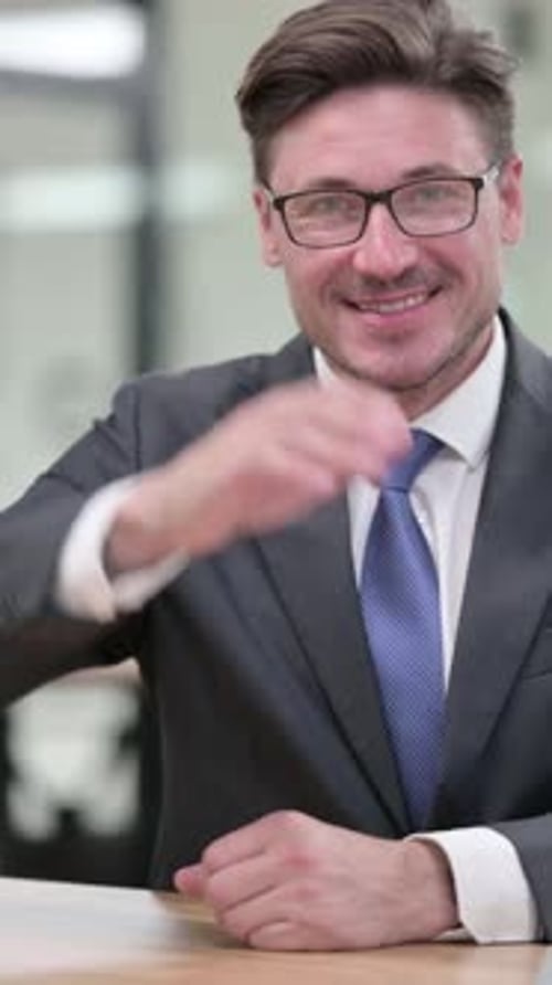 Confident Businessman Extending Hand for Handshake in Office