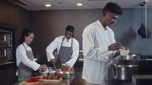 Head Chef Cooking Soup, Sous Chefs Preparing Ingredients for Pasta at Restaurant