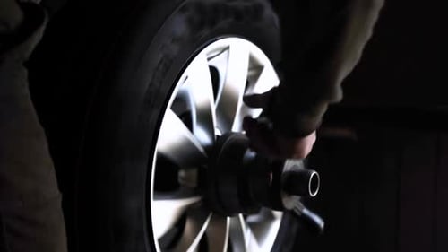 Car wheel service. Mechanic changing tires and rims, balancing the wheels