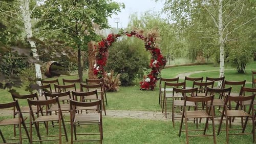 Red Arch and Wooden Chairs in the Park Slow Motion Shot
