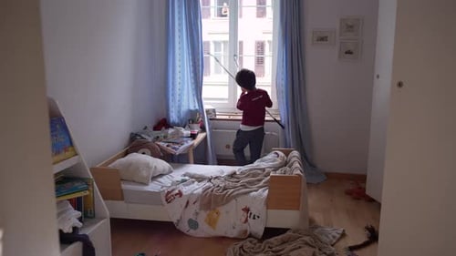 Boy standing near bed in messy room, looking down, day scene, everyday childhood moment in typical