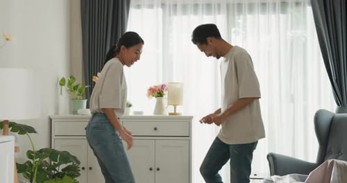Playful Couple Dancing Together in Living Room