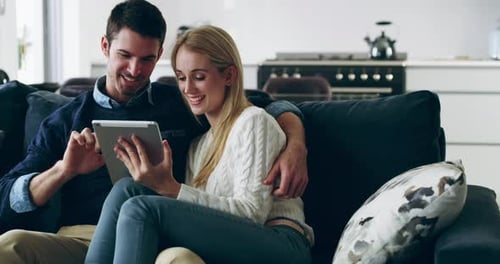 Couple Relaxing on Couch with Tablet at Home