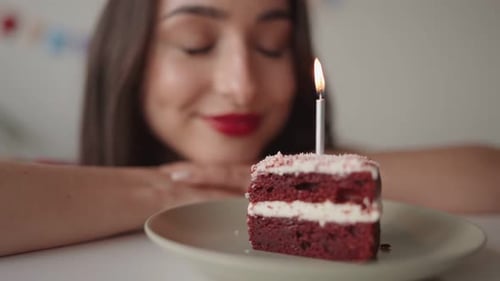 Happy Woman Celebrates Birthday with Cake and Candle