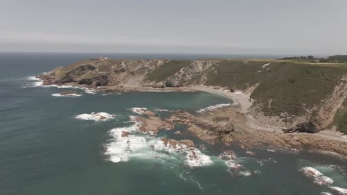 View From the Top of a Cliff with the Waves Crashing Against the Rocks
