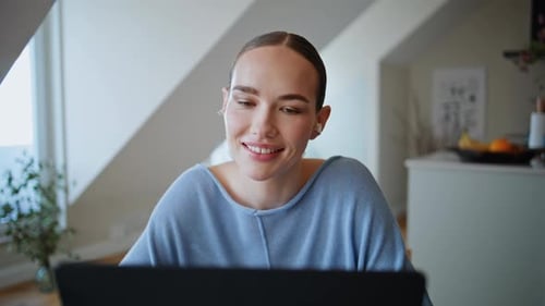 Smiling Woman Working on Laptop at Home