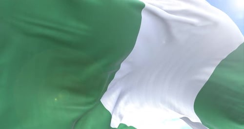Realistic Waving Flag of Nigeria Against Blue Sky