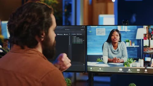 Man Attends Virtual Meeting on Dual Monitors