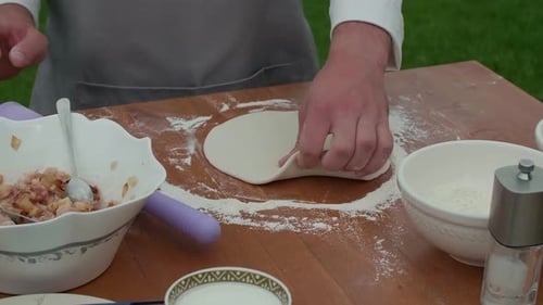 Chef Flattens Dough with Rolling Pin