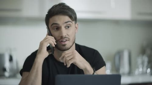 Smiling Man Talking on Phone in Kitchen