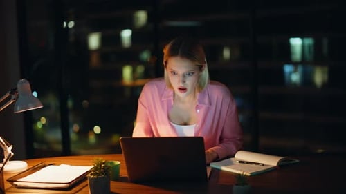 Worried Woman Reacting to Computer Screen at Night