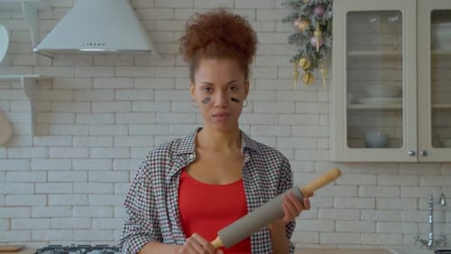 Woman with Rolling Pin Poses in Kitchen