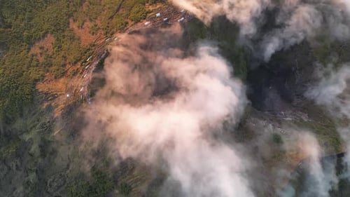 Top-down aerial view of Batur volcano in clouds at sunrise, Bali, Indonesia