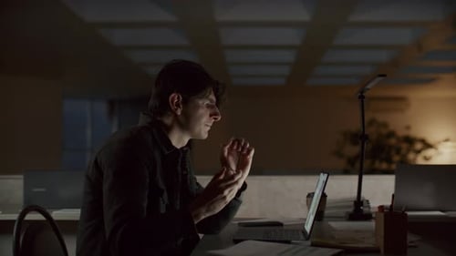 Young Man Finishing Work on Laptop and Leaving Office at Night