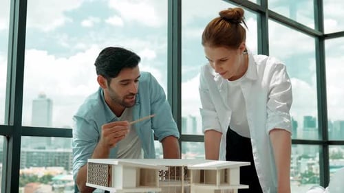 Architects Discussing Building Model in Modern Office