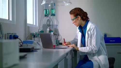 Female Scientist Working in Lab Writing Notes
