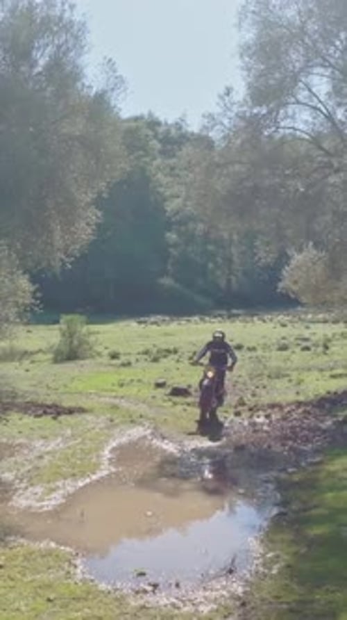Man Rides Dirt Bike Through Watery Field