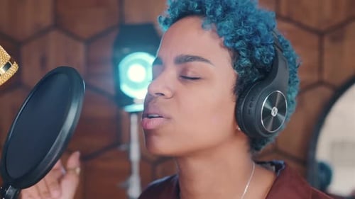 Young Adult Singing Into Microphone in Recording Studio
