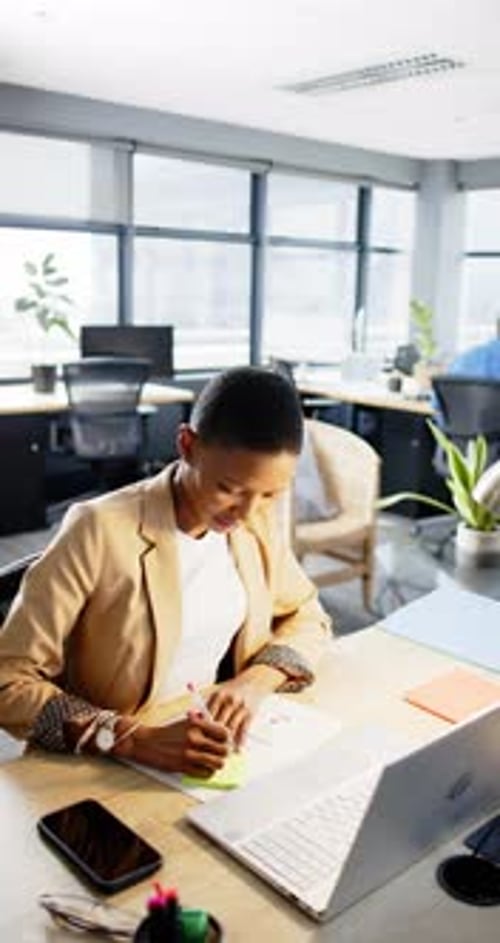 Vertical video of african american businesswoman working in office, slow motion, copy space