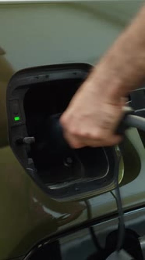 Vertical Video Close Up of Driver Disconnecting EV Vehicle From Charging Dock