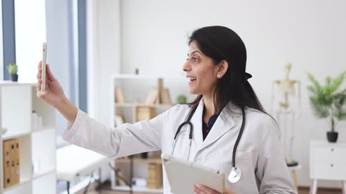 Smiling Woman Doctor Telemedicine Video Call in Office