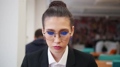 A Young Woman Sitting in the Office and Working with