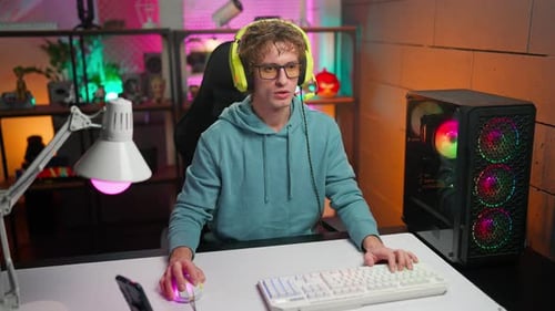 Young Adult Playing Video Games at Desk
