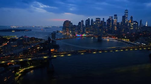 Bridges over the East River with lively traffic at night. Magnificent skyscrapers with lights