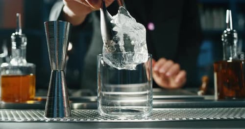 Close up of a professional bartender is preparing an alcoholic cocktail with professional crystal