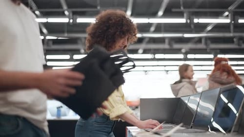 Couple choosing laptop bag in electronics store in slow motion