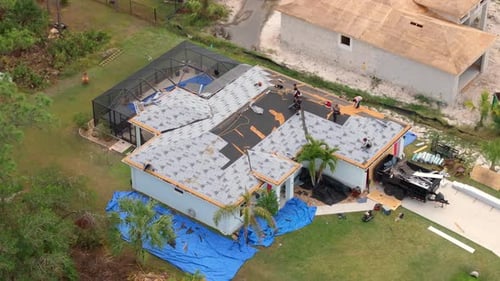 Aerial View: Roofers Working on House in Suburban Neighborhood