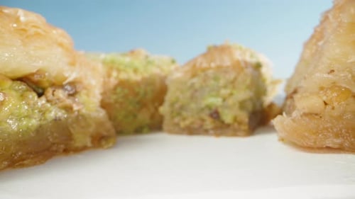 Turkish baklava with pistachios and walnuts. Under the blue sky. Dolly slider extreme close-up.