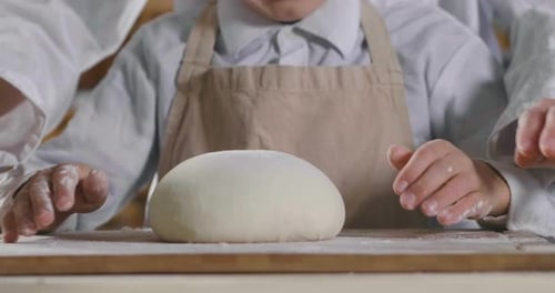 Close up of a baker kneading with his hands to prepare the bread to put in the oven. Concept of: a