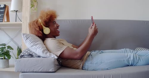 Smiling Young Adult Video Chatting on Phone at Home