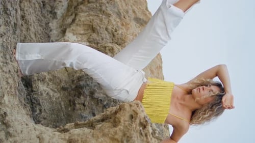 Woman Posing in White and Yellow on Rocky Beach
