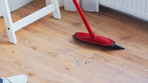 Broom Sweeping Debris on Light Wooden Floor Indoors