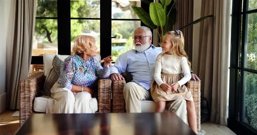 Grandparents, girl child and talking in lounge with care, story and happy with bonding in family