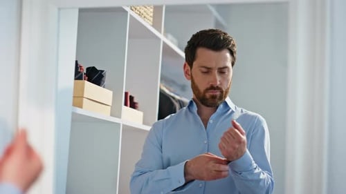Man in Blue Shirt Gets Dressed in Closet