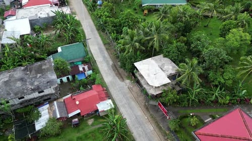 aerial tilt down tropical southeast asia neighborhood or village on sunny day