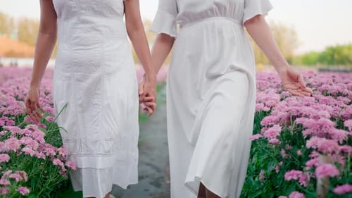 Girl and friend running happily in pink flower garden