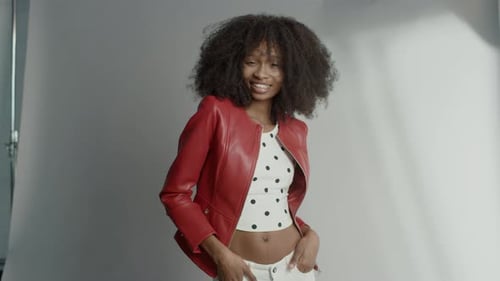 Smiling woman with curly hair posing in studio