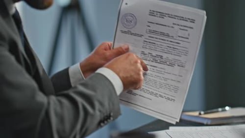 Excited Businessman Reviews Legal Documents in Office