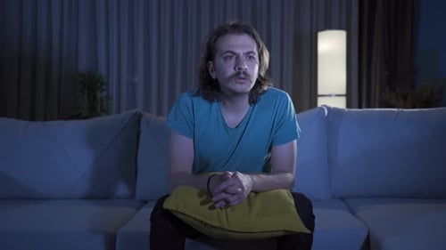 Man Watching TV in the Dark Living Room