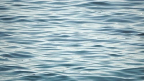 Meereswasseroberfläche, niedriger Winkel, Blick über klares azurblaues Meerwasser, Sonnenblendung, abstrakter nautischer Sommerozean