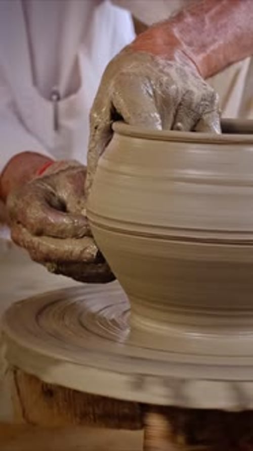 Des mains expertes de potier façonnent l'argile sur un tour de potier et sculptent un pot en argile