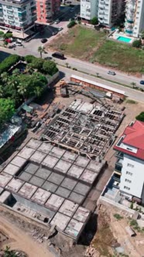 Los constructores e ingenieros de vídeo vertical colaboran para preparar el vertido de concreto para las casas del