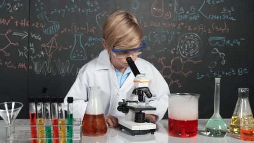 Young Boy Scientist with Microscope in Laboratory