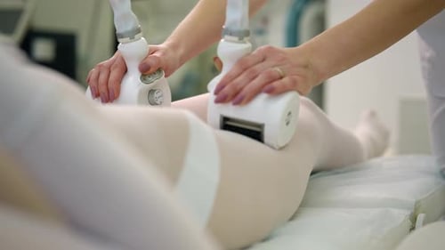 Medical Staff Uses Machine on Legs Covered in White